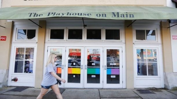 A resident walks past the Starkville Community Theatre in downtown Starkville, Miss., Thursday, Feb. 22, 2018. The doors are decorated with colored panels representing the LGBTQ rainbow flag, done in support to an effort mount the Mississippi college town's first-ever gay pride parade. Starkville aldermen voted 4-3 Tuesday to deny the parade permit requested by Starkville Pride, an LGBT support group. (AP Photo/Rogelio V. Solis)
